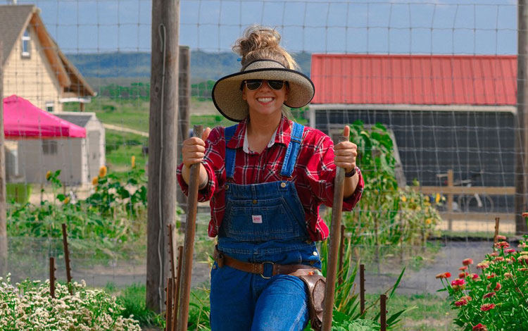 Woman tilling garden.